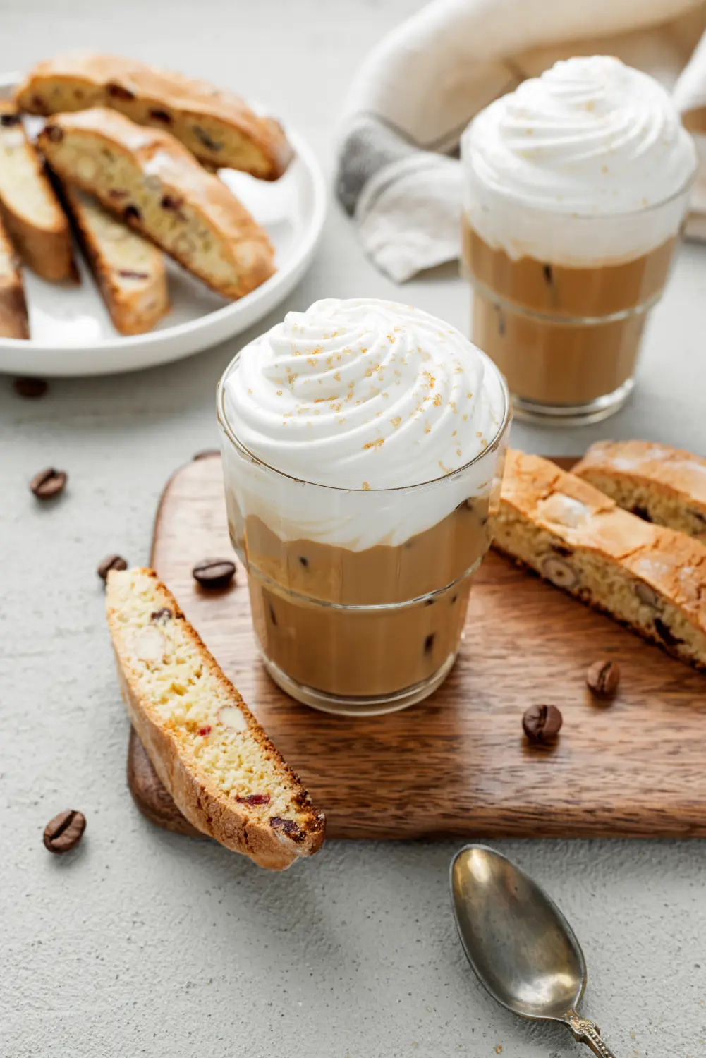 Eiskaffee-Latte mit Schlagsahne und Biscotti-Keksen im Glas.